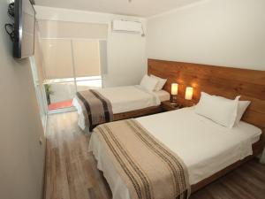 兰卡瓜De Triana Hotel的酒店客房设有两张床和电视。