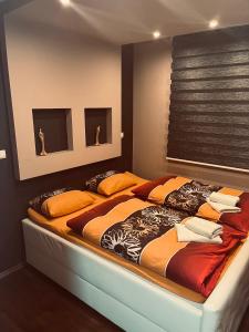 布尔奇科Apartman Centar的一间卧室配有一张带橙色枕头的大床
