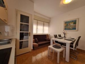 普拉Ferienwohnung für 4 Personen ca 64 qm in Pula, Istrien Istrische Riviera - b61675的厨房以及带桌子和沙发的客厅。