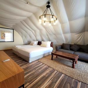 Al ḨamrānīyahDesert Breeze的一间卧室配有一张床,一张沙发位于帐篷内