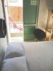 弗洛里亚诺波利斯Loft pé na areia的窗户和椅子的房间里的一个床位