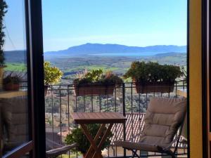 马利亚诺因托斯卡纳Ferienwohnung für 4 Personen ca 40 qm in Magliano in Toscana, Toskana Maremma的阳台配有桌椅,享有风景。