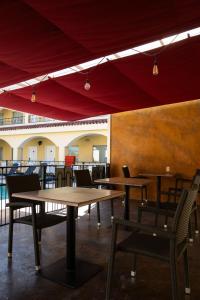 蒙克洛瓦Hotel Las Misiones的一间带桌椅和红色天篷的餐厅