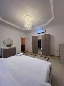 吉达شقق جدة دستنيشن的卧室配有一张白色大床和吊灯。