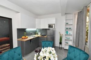 格拉达茨Nettes Appartement in Gradac mit Terrasse的厨房配有白色橱柜和蓝色椅子