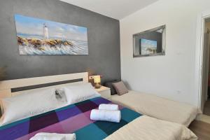 格拉达茨Nettes Appartement in Gradac mit Terrasse的一间卧室设有两张床,墙上挂着一幅画