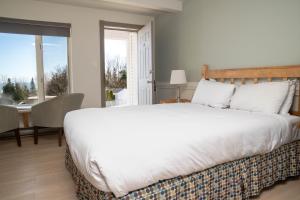 拉马巴耶三只鸭旅馆的卧室配有一张白色的大床和一张桌子