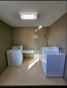 胡尔伯克Super 8 by Wyndham Holbrook的洗衣房配有洗衣机和烘干机