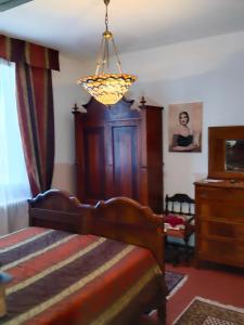 克雷斯佩拉诺La Maison Rouge的一间卧室配有一张床和一个吊灯