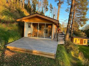 Ferienhaus in Västerrå mit Garten und Terrasse的树林中带甲板的小房子
