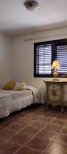 罗萨里奥港AKASHA的一间卧室配有一张床和一张带台灯的桌子