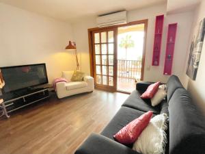 圣埃乌拉利亚Ensuite Double Room with Sea View in a Shared Apartment in the Centre of Santa Eularia - close to the Beach的带沙发和电视的客厅