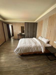 斗六市云林斗六太信大饭店的一间卧室配有一张大床和一张书桌