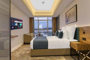 吉达ِAluya Hotel的酒店客房设有一张床和一个大窗户