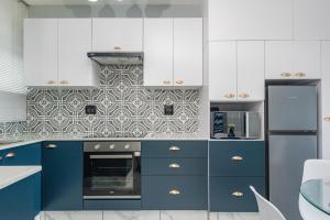 巴利托Trendy @ La Ballito 503的厨房配有蓝色橱柜和白色家电