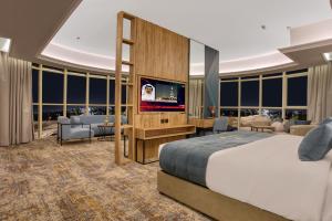 吉达ِAluya Hotel的一间卧室配有一张床和一台平面电视