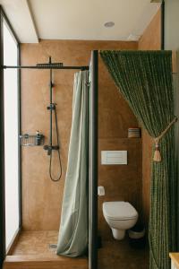 塔里法Casa Africa的浴室设有卫生间和带浴帘的淋浴。