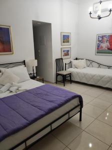 干尼亚Porto Chania的一间卧室配有两张床、一张沙发和一把椅子