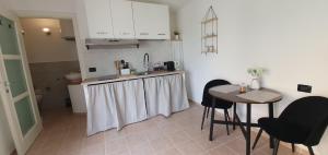 奥尔比亚Eleonora's apartment的厨房配有柜台和桌椅