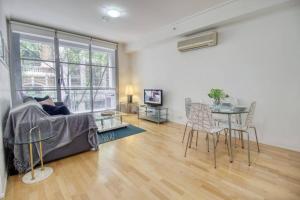 悉尼Superb Apartment in an Heart of Sydney' CBD的客厅配有沙发和桌子