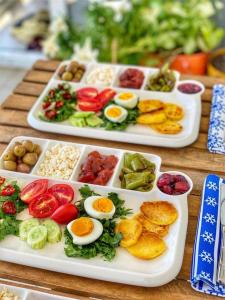 达拉曼Dalaman Airport AliBaba House的桌上的两盘食物,包括鸡蛋和蔬菜