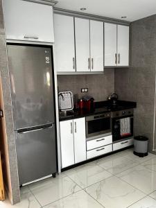 马拉喀什Riad Jad - Sweet Duplex Appartement的厨房配有白色橱柜和不锈钢冰箱