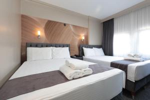 伯萨Loyal City The Best Hotel in Bursa的酒店客房,配有两张带毛巾的床