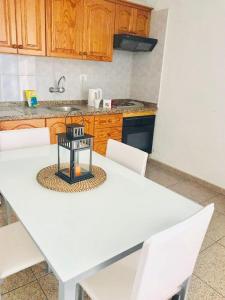 美洲海滩Ferienwohnung für 6 Personen ca 60 qm in Playa de Las Américas, Teneriffa Playa de Las Américas und Los Cristianos的厨房配有白色的桌子和白色的椅子