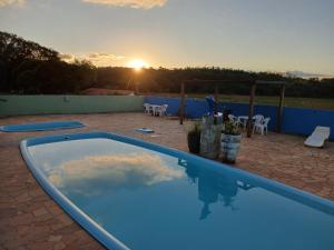 皮拉茹Hotel Fazenda Recanto do Monte Alegre的一座享有日落美景的游泳池