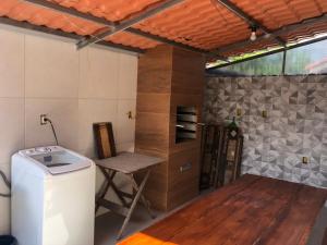 塞拉Casa Exclusiva a 400 Metros da Praia em Manguinhos - Condomínio com Vigilância 24hs的一间带桌子和炉灶的小厨房