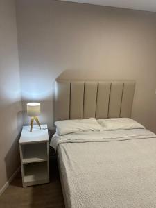 利马Friendly Apartment Tamayo的一间卧室,配有一张床和床头灯