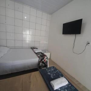 伊塔帕里卡Pousada Estelita的小房间设有一张床和一台平面电视