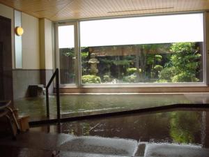 鸟取市Tottori Onsen Shiitake Kaikan taisuikaku - Vacation STAY 21957v的一间设有花洒淋浴和大窗户的客房