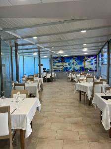 雷维拉-德卡马戈玛丽亚别墅酒店的一间设有白色桌椅和壁画的餐厅