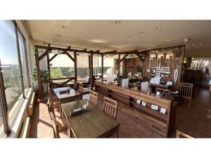 音更町Hotel Hounomai Otofuke - Vacation STAY 29507v的餐厅设有木桌、椅子和窗户。