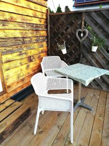 费尔特拉科什Ferienhaus in Fertrákos mit Garten, Terrasse und Grill的木甲板上配有两把椅子和一张桌子