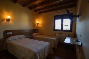 Ferreras de ArribaLa Guarida de la Lleira的酒店客房设有两张床和窗户。