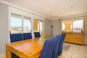 布索特Felderhof Villa 4 bed Private Pool的一间带木桌和蓝色椅子的用餐室