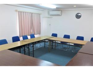 Kikai Daiichi Hotel - Vacation STAY 30456v的一间会议室,配有木桌和蓝色椅子