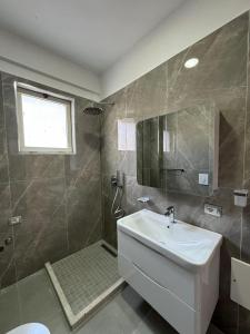 都拉斯Vila Melisa的浴室配有白色水槽和淋浴。