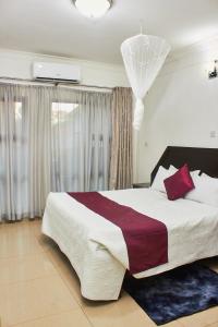 ZombaMango Lodge Zomba的一间卧室配有一张带红色枕头的大床