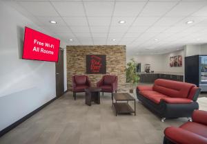 兰开斯特Red Roof Inn Lancaster, TX的大堂设有红色的沙发、椅子和标志