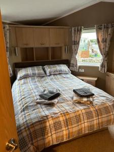 科克茅斯Daffodil Lodge的一间卧室配有一张床,上面有两条毛巾