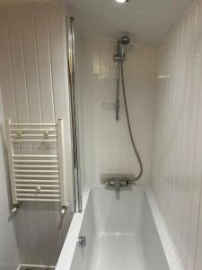 科克茅斯Daffodil Lodge的白色的浴室设有浴缸和淋浴。