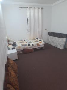 Şūr Maşīrahشقة في جعلان ( بيت عربي) اجار يومي واسبوعي的一间卧室配有床和带窗帘的窗户