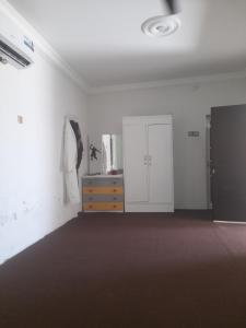 Şūr Maşīrahشقة في جعلان ( بيت عربي) اجار يومي واسبوعي的一个空房间,配有梳妆台和白色的墙壁