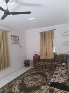 Şūr Maşīrahشقة في جعلان ( بيت عربي) اجار يومي واسبوعي的带沙发和吊扇的客厅