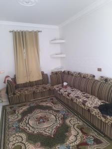 Şūr Maşīrahشقة في جعلان ( بيت عربي) اجار يومي واسبوعي的客厅配有两张沙发和地毯。