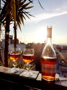 雅典Αfrodite! Roof top studio--Wonderful city view的桌子上放有一瓶葡萄酒和两杯酒