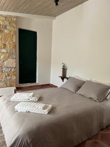 JuncalQuinta dos Avós的一间卧室配有一张大床和毛巾